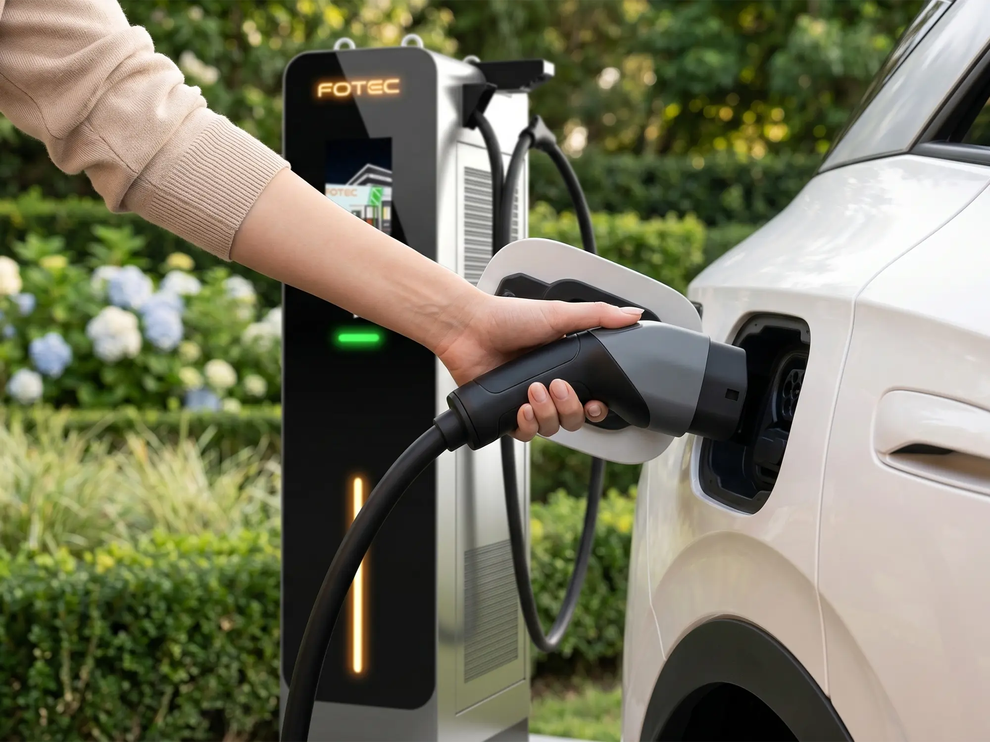 Antalya'da modern bir konut otoparkında duvara monte edilmiş Type 2 konnektörlü AC elektrikli araç şarj istasyonu ve şarj kablosu takılı elektrikli araç